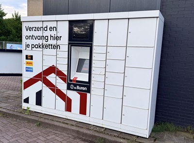 Een grote witte kast (pakketwand), met daarop onder andere een sticker met een NedLinq logo. De kast bestaat uit ongeveer 35 kleine kasten met afgesloten deuren. In het midden van de pakketwand zit een aanraakscherm.